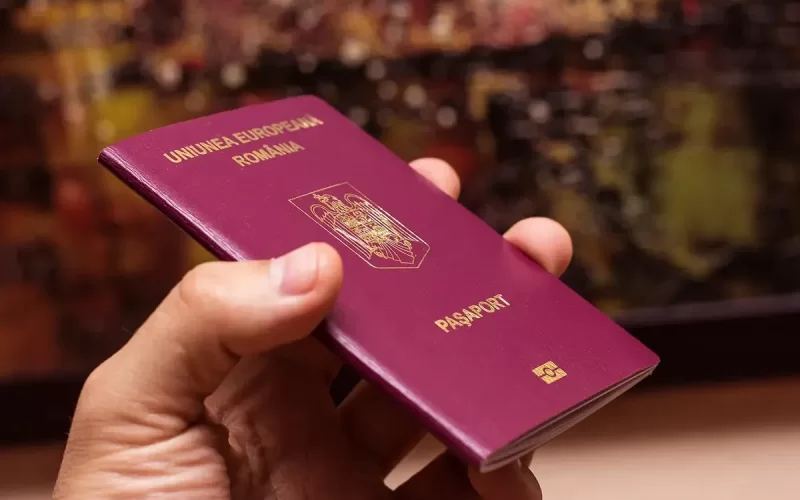 Паспорт Румунії в руках, символ європейської ідентичності та можливостей подорожей.