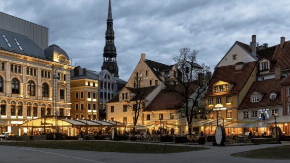 Сучасна архітектура в центрі міста з історичними будівлями, освітленими вечірнім світлом та затишними кафе на відкритому повітрі, декоративно оформленими вуличними зонами.