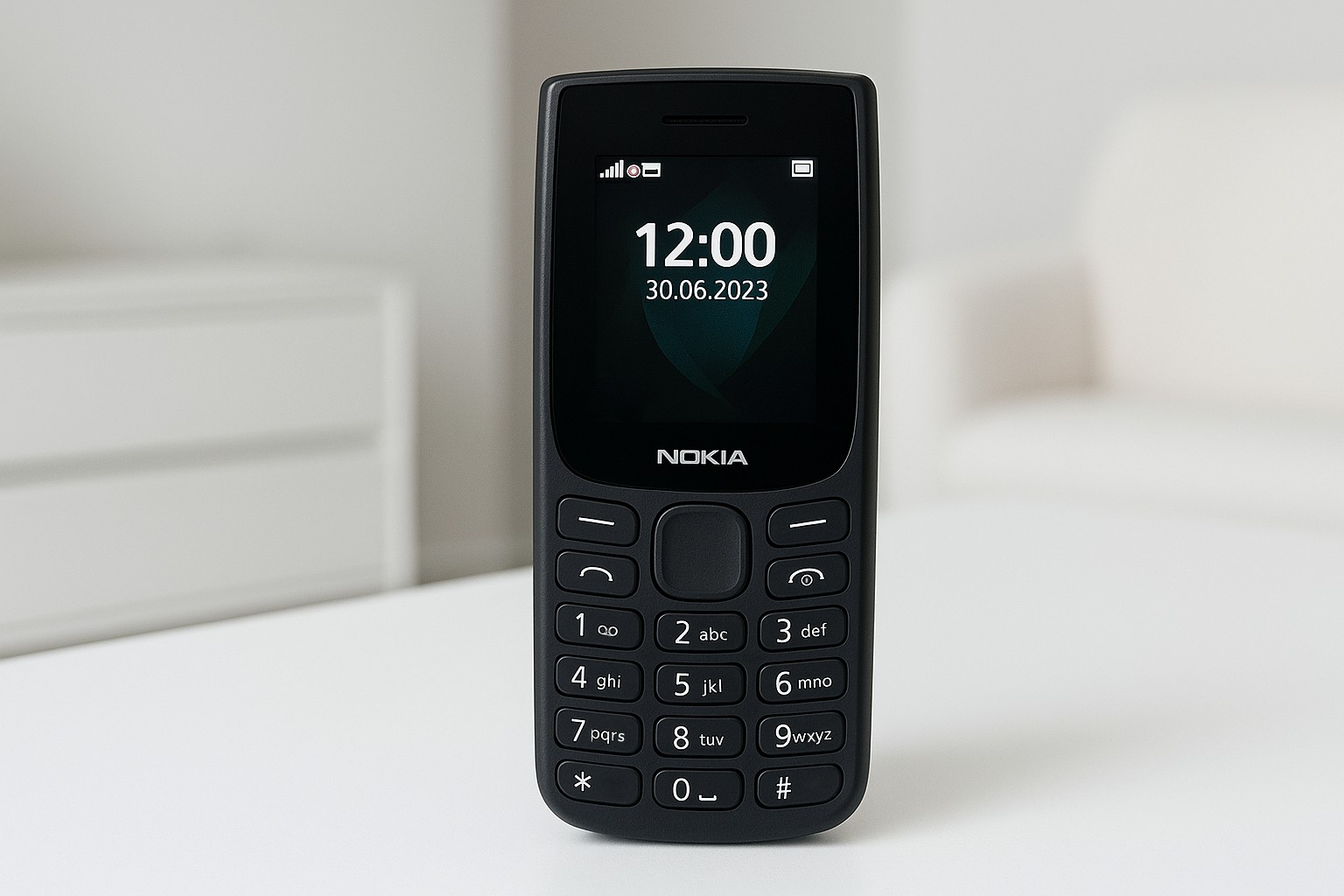 Класичний мобільний телефон Nokia чорного кольору стоїть на білому столі в світлій кімнаті; на екрані видно час 12:00 та дату 30.06.2023.