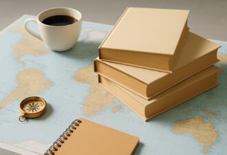 Стопка бежевих книг без обкладинок на фоні карти світу з компасом, блокнотом і білою чашкою кави на сірій поверхні під нейтральним світлом.
